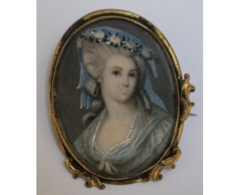 A LATE 19TH / EARLY 20TH CENTURY OVAL PORTRAIT MINIATURE OF A YOUNG LADY IN A BLUE HAT, in an oval decorative gilt metal broo