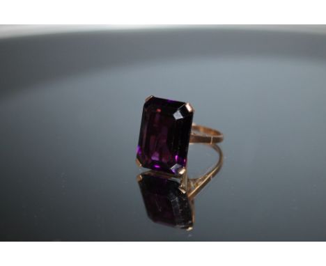 A LARGE EMERALD CUT AMETHYST RING, measuring approx 18mm x 14mm, set in unmarked yellow metal, approx weight 8.3g, ring size 