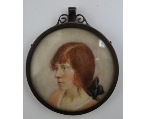 AN EARLY 20TH CENTURY CIRCULAR PORTRAIT MINIATURE OF A GIRL WITH RED HAIR, in circular metal frame, unsigned, framed and glaz