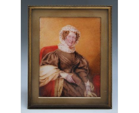 A NINETEENTH CENTURY PORTRAIT MINIATURE OF A SEATED LADY IN A BROWN DRESS AND WHITE BONNET, in a gilt metal frame with strut 