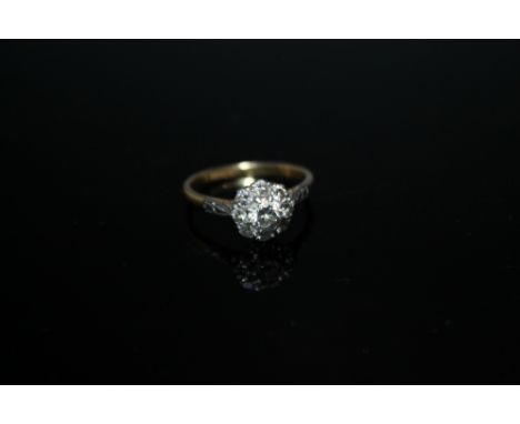 AN 18 CT GOLD DIAMOND CLUSTER, with diamond set shoulders, the central diamond being approx 0.25 ct, ring size O