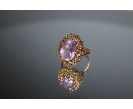 A HALLMARKED 9 CARAT GOLD AMETHYST RING, in ornate high set gallery, approx 14 mm x 10 mm, approx weight 6.3g, ring size O