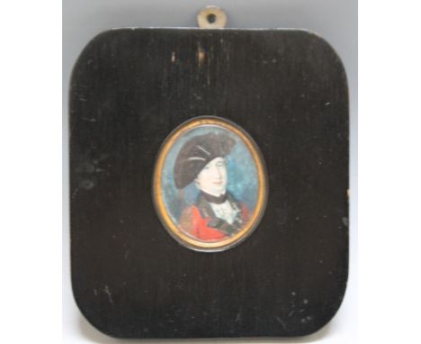 A 19TH CENTURY OVAL PORTRAIT MINIATURE OF AN OFFICER IN RED UNIFORM AND BLACK HAT, in a black framed, unsigned, framed and gl