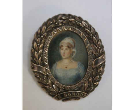 A LATE 19TH / EARLY 20TH CENTURY OVAL MINIATURE PORTRAIT OF A YOUNG WOMAN IN A BLUE DRESS, in an oval hallmarked silver brooc