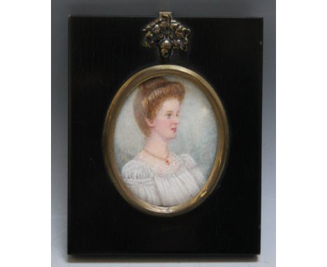 A LATE 19TH / EARLY 20TH CENTURY OVAL PORTRAIT MINIATURE OF A LADY IN A WHITE DRESS AND RUBY NECKLACE, in a black frame with 