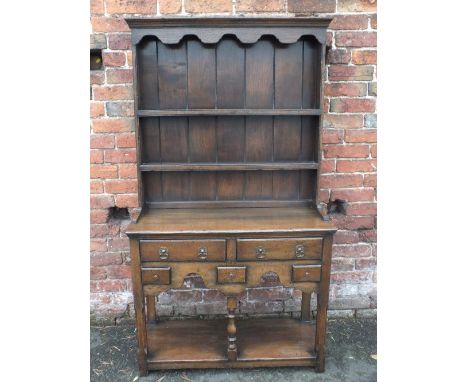 A SMALL REPRODUCTION OAK DRESSER POSSIBLY BY TITCHMARSH &amp; GOODWIN, the panelled plate rack above a base with an arrangeme