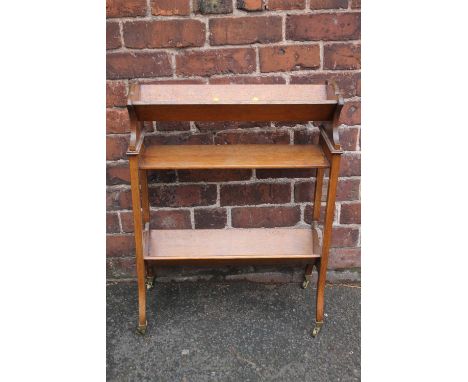 A 1920S OAK BOOK TROUGH, of three stages with shaped supports and original cappings and castors, H 73 cm, W 58 cm