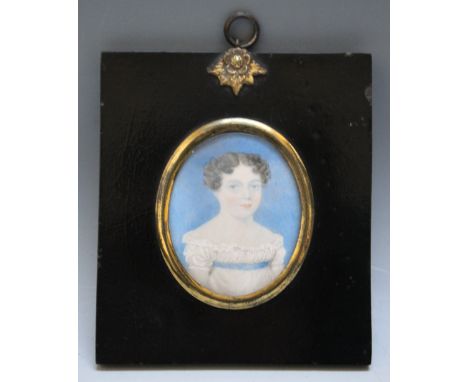 A 19TH CENTURY OVAL PORTRAIT MINIATURE OF A YOUNG WOMAN IN A WHITE DRESS WITH BLUE SASH, in a black frame with gilt metal fin