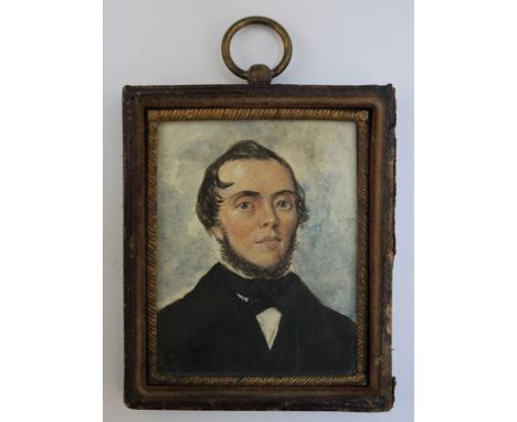 A LATE 19TH / EARLY 20TH CENTURY PORTRAIT MINIATURE OF A GENTLEMAN WEARING A BLACK COAT AND BOW TIE, in a leather frame, unsi