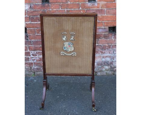 AN EDWARDIAN MAHOGANY FIRESCREEN WITH MATERIAL LINING AND STITCHED CREST WITH MOTTO 'DUM VIGOLO TUTUS', with additional pull-