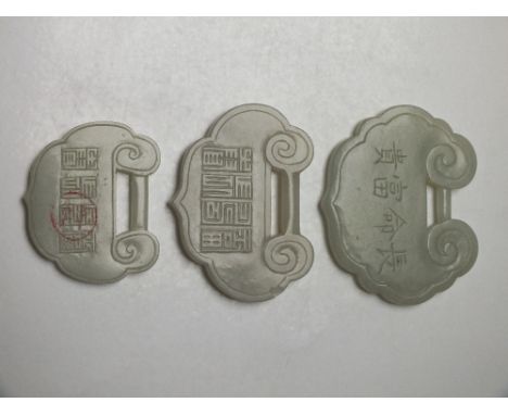 THREE CHINESE CELADON JADE LOCK PENDANTS, in graduating sizes, given as a token of long life, finely carved in shallow relief