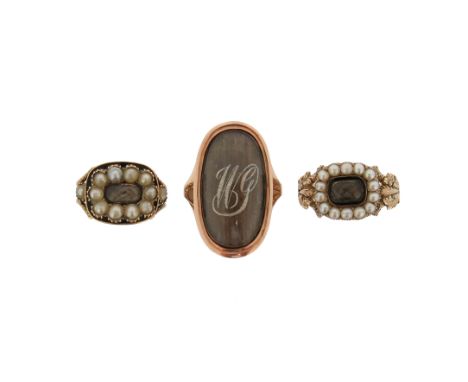 A group of three early 19th century mourning rings, including a seed pearl and black enamel mourning ring, with glazed locket