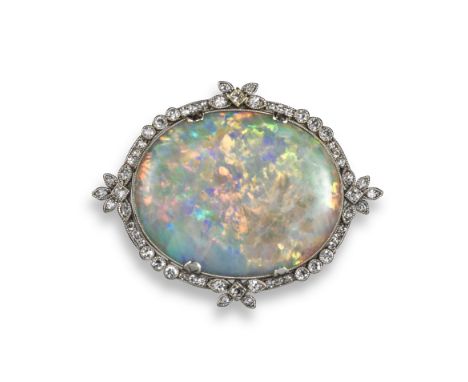 An Edwardian opal and diamond brooch, the oval opal cabochon set within foliate diamond-set border millegrain-set in platinum