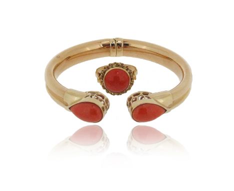 A coral and gold bangle, each terminal mounted with a pear-shaped coral cabochon, set in yellow gold, hinged opening, 5.7cm i