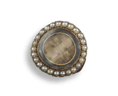 A late 18th century seed pearl and gold mourning ring, set with a central circular locket containing plaited hair within circ