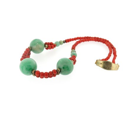 A coral and jade bead necklace, set with seven graduated spherical jade beads between double rows of faceted coral beads, on 