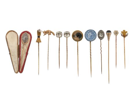 A group of eleven stickpins, including a reverse carved crystal dog stickpin, a cabochon garnet set in yellow and gold spiral