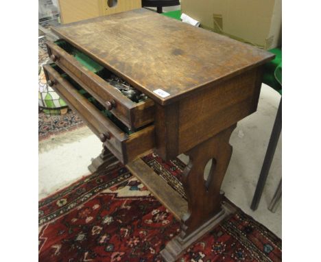 An oak canteen table, the plain top above two fitted drawers with plated cutlery, raised on lyre shaped end pillar supports u