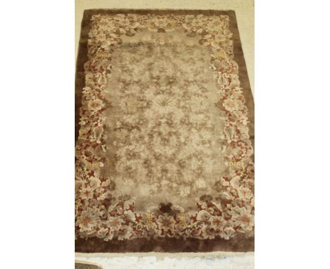 An Art Deco Chinese carpet, the central panel set with floral sprays in brown and cream, within a floral and Chinese motif de