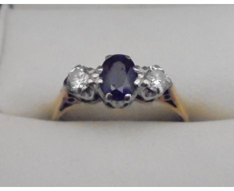 An 18 carat gold dress ring, the central sapphire flanked by two diamonds