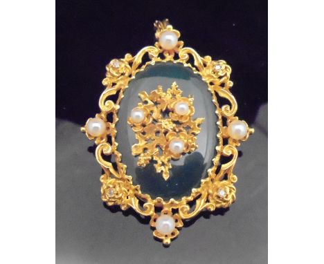 A 9 carat gold mounted pendant / brooch set with central oval jade panel, seed pearls and diamonds within floral sprays, bear