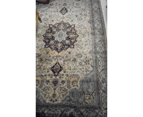 A Persian carpet, the central panel set with a flower head medallion within a cream floral decorated ground and a stepped pin