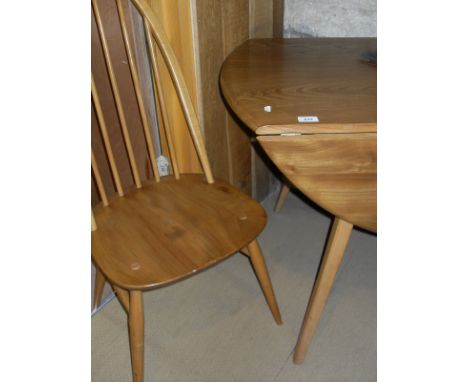 A light elm Ercol drop leaf dining table and four stick back dining chairs with elm seats, beech backs and legs