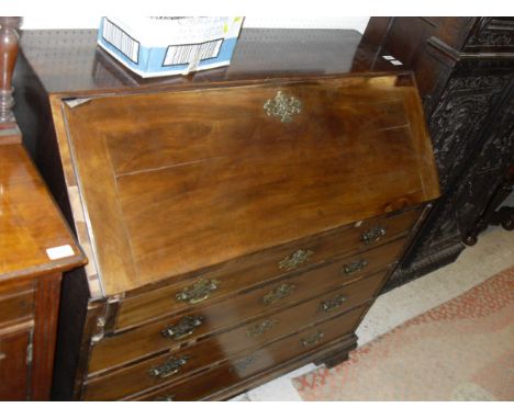 A late George III mahogany bureau, the sloping fall enclosing a basic fitted interior over four long drawers to ogee bracket 