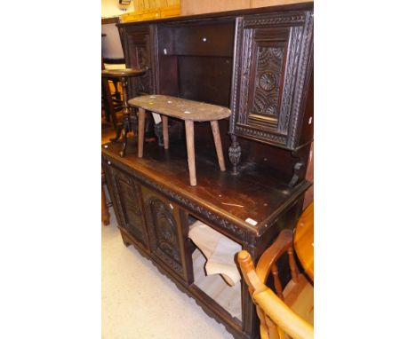 A 19th Century carved oak dresser with two carved panelled doors flanking an open recess above a base of two doors, raised on