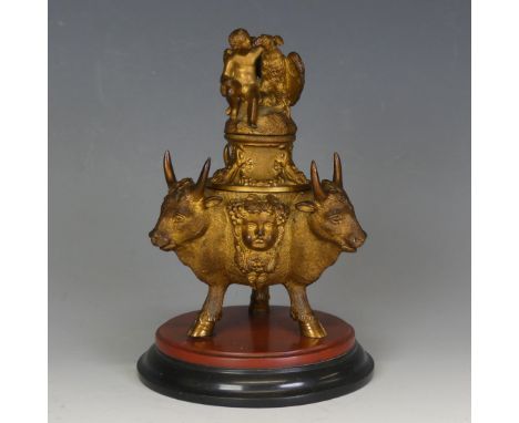 A 19thC French gilt-metal Inkwell, base depicting alternating bulls heads, grapes and Putti, top cover surmounted by a model 