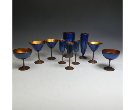 A set of French enamel on copper Drinking Vessels, comprising Flutes, Martini Glasses and Goblets, on copper stems with engra