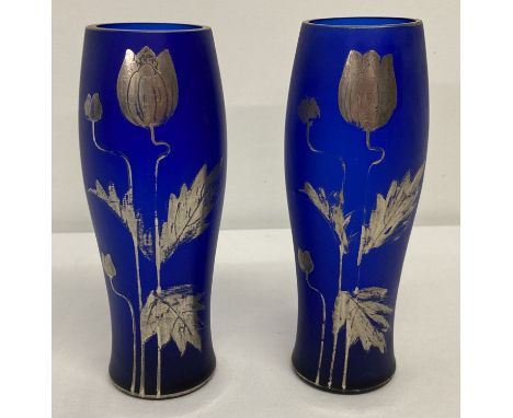 A pair of dark blue glass vases with silver Art Nouveau style floral decoration.   Approx. 15cm tall.