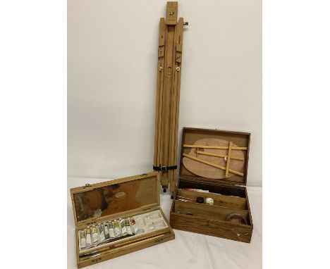 2 wooden boxes of artists paints, brushes and accessories together with a wooden tripod easel.  