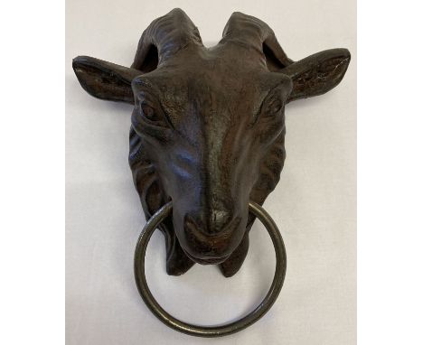 A large cast metal door knocker in the form of a goats head, with ring.   Approx. 26cm long.