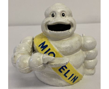 A painted cast metal advertising Michelin man mechanical money box.  With lever arm action.  Approx. 11cm tall.