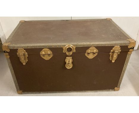 A large travelling trunk with metal banding, corner guards and leather carry handles.   Approx. 91 x 51 x 51cm tall.