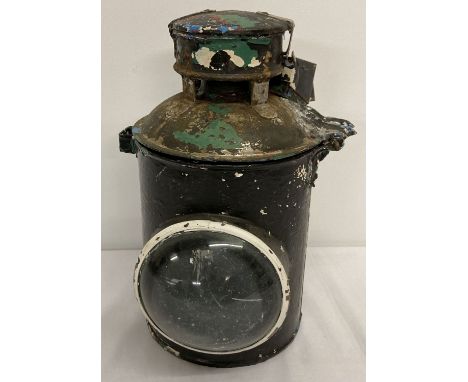 A vintage painted metal railway lamp with large domed clear glass lens.  Aged leaded repair to hinge.  Approx. 33cm tall.