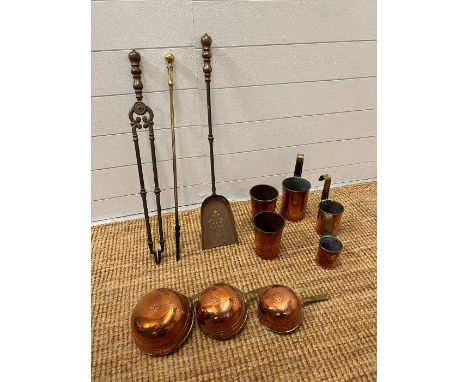 Brass fireside tools and a collection of copper measuring cups