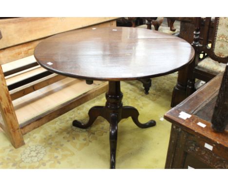 A George III oak fill top tripod table, turned column and standing on cubicle legs, together with an Edwardian mahogany table