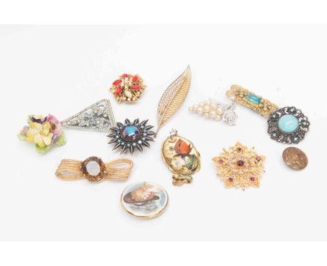 A collection of costume jewellery to include paste set brooches, ceramic versions, and a pair of screw on earrings