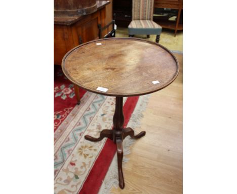 A George III mahogany circular topped tripod table, having a dished circular top, 