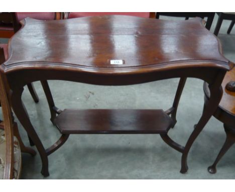 A shaped top splayed leg occasional table with stretcher shelf