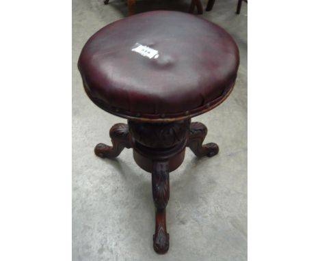 An adjustable piano stool on carved tripod base with circular top