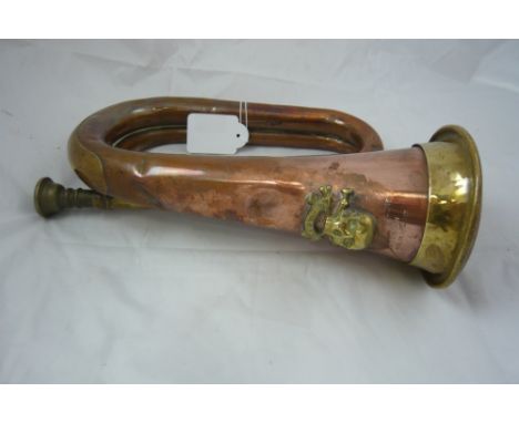 A copper bugle by John Grey and Sons London, bearing the badge of the 17th century lancers, 21cm long