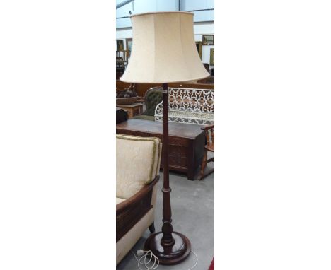A mahogany standard lamp on circular base