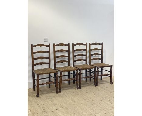 A set of four early 20th century stained oak ladder back chairs, with rush seats and turned supports H97cm