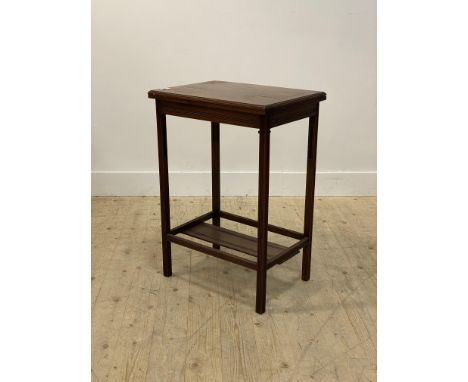 An Edwardian walnut card table, the fold over revolving top opening to a baize lined playing surface, raised on tramline moul