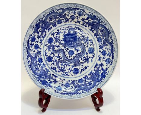 A large modern Chinese blue and white charger decorated with central rounded depicting five-claw dragon (apocryphal six-chara