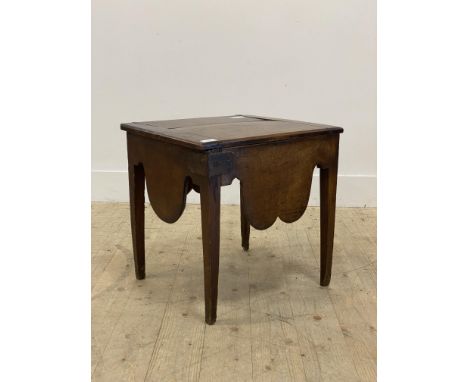 A George III mahogany, elm and oak commode, the hinged top opening to a recess above shaped apron and raised on square tapere