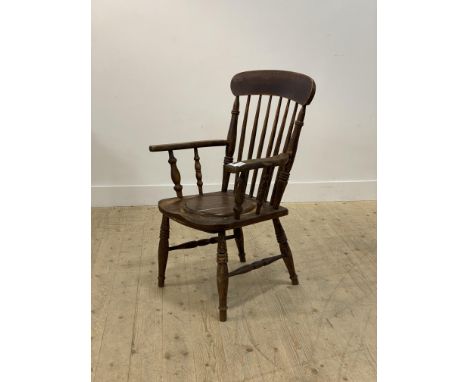 A Victorian stained mahogany Windsor type commode chair, with comb back over saddle seat, raised on turned supports with an H